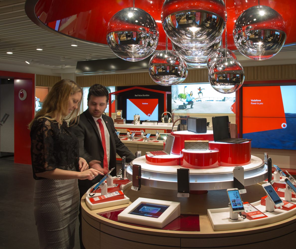 Staff helping customer at Vodafone Harrods midfloor unit, Luxury Retail Experience Design by Household.